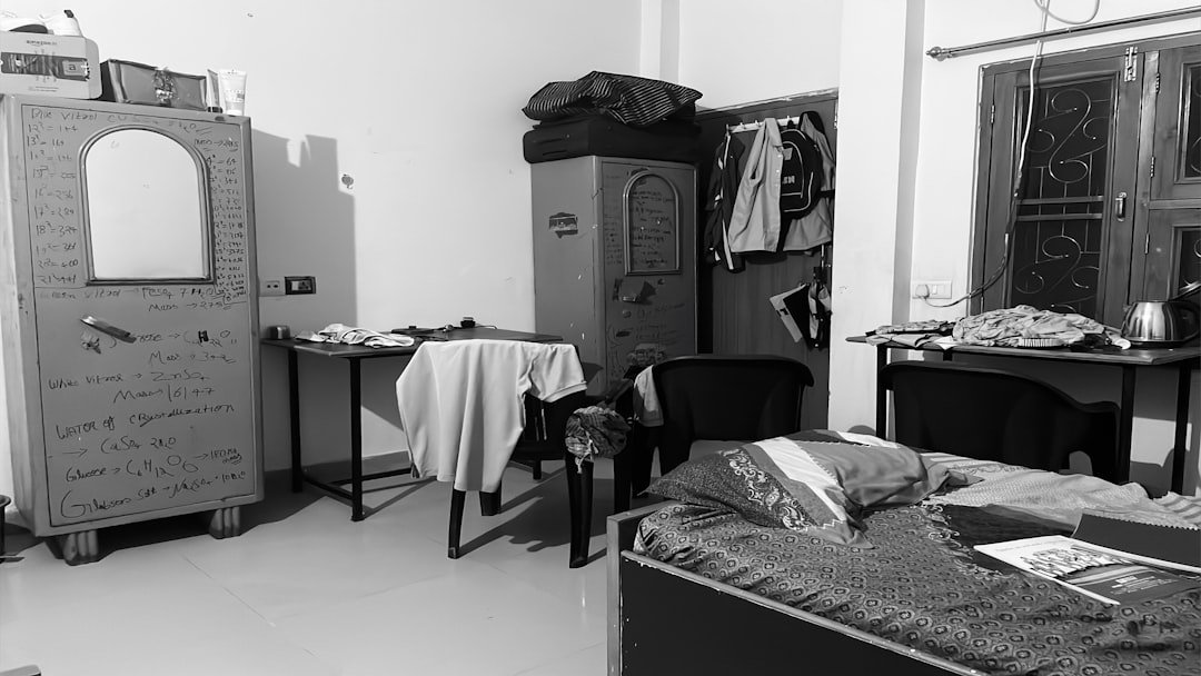 A lived-in bedroom with clothes collecting on chairs, tables, and hooks.