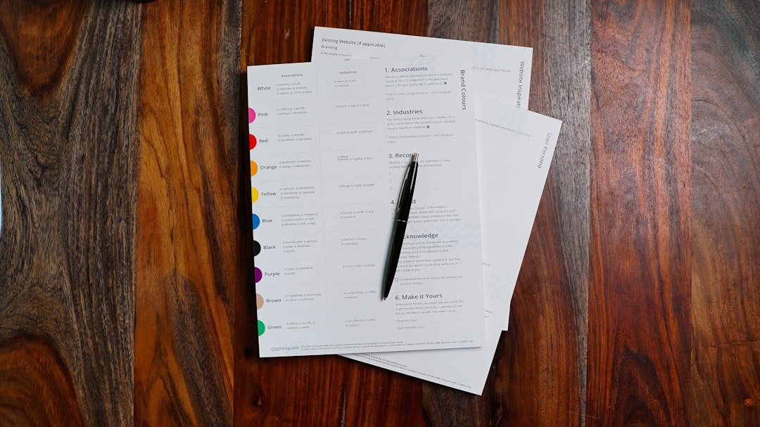 Loose household papers and a pen arranged on a wooden table.