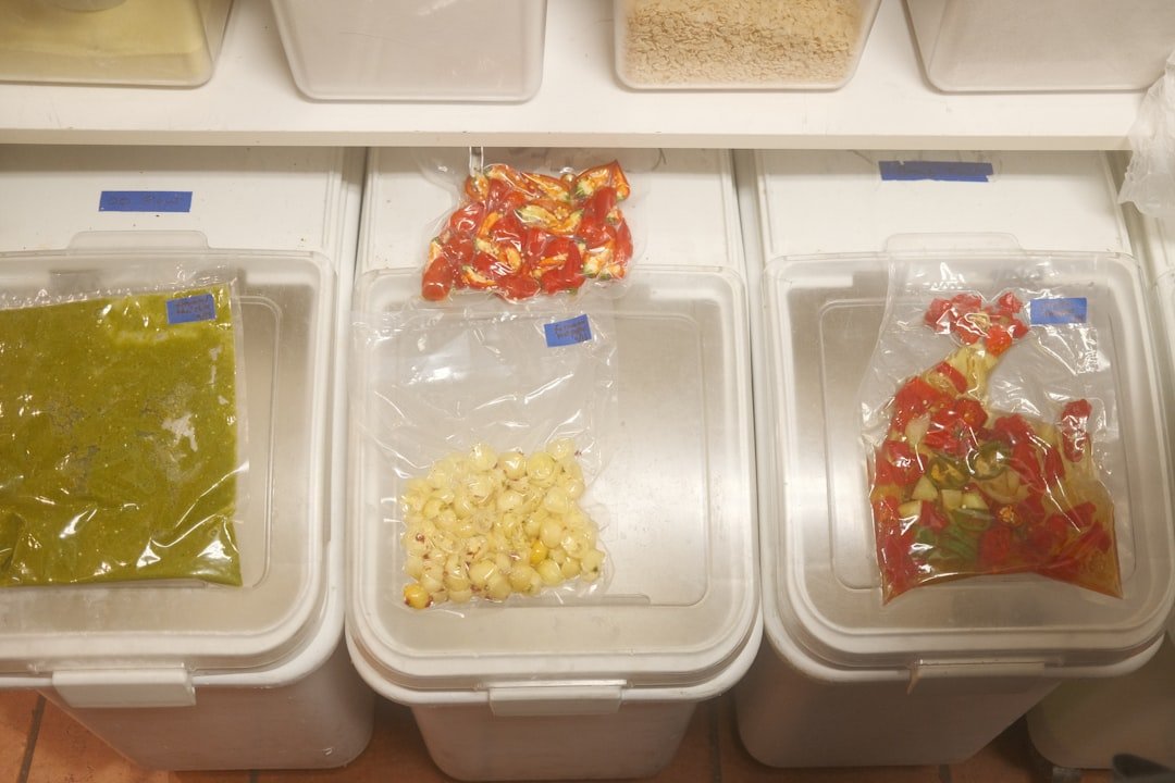Labeled frozen-food bags sorted into clear containers inside a freezer.