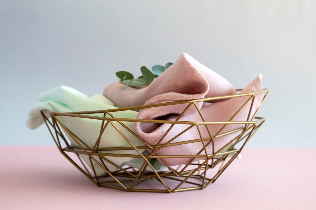 Reusable cleaning cloths folded together in a wire basket.