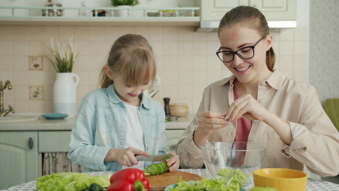 Mother and daughter preparing salad in kitchen